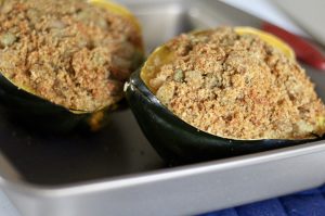 stuffed acorn squash on a baking sheet.