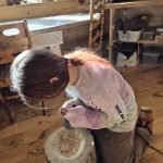 Youth grinding acorns into flour.