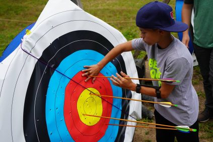 Camper removing arrows from a archery target
