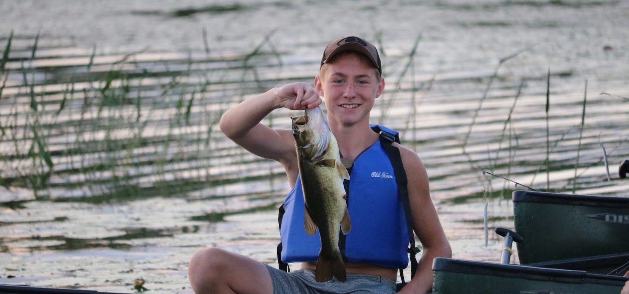 Camper holding large mouth bass