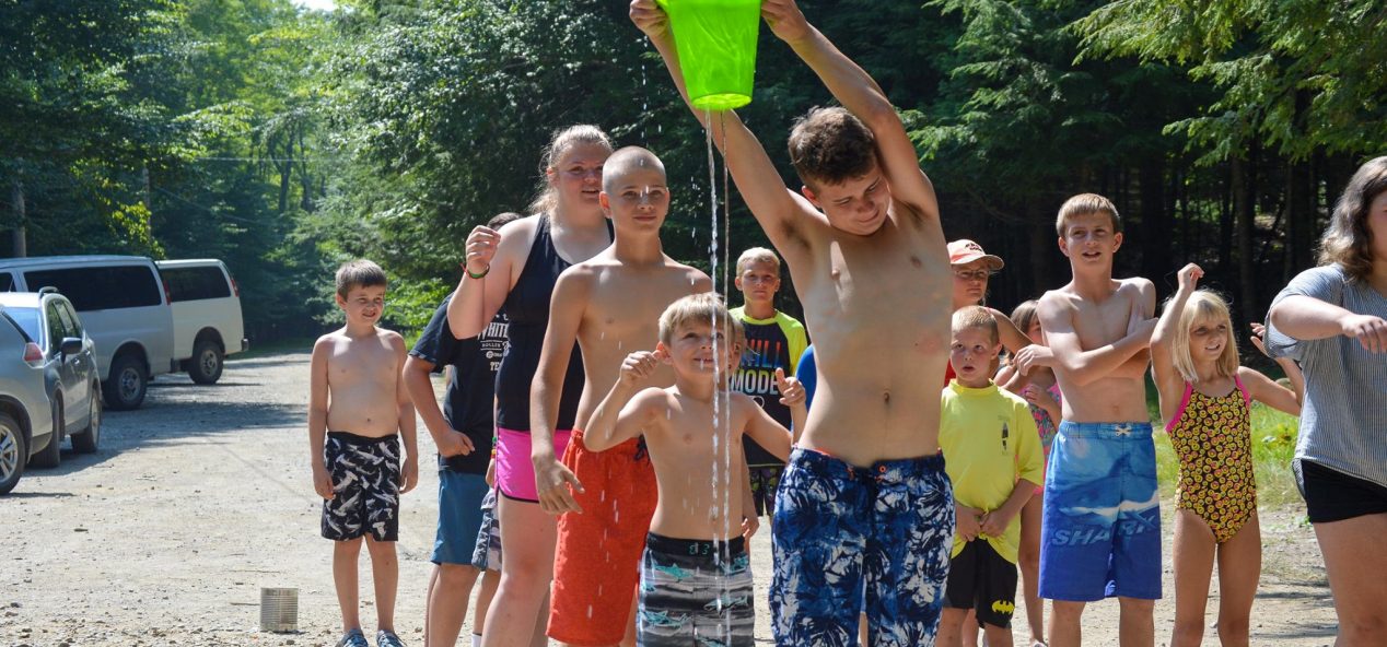 Campers playing with water bucket on a hot day