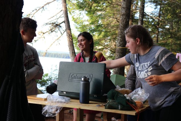 Campers prepping a meal on trip