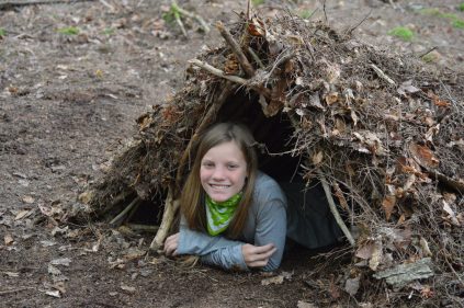 camper laying in debris shelter