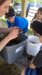 Jamboree volunteer teaching youth about worm composting