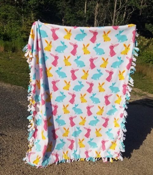 Fuzzy fleece tie blanket with colorful bunnies on it made by the Horse of Course 4-H club