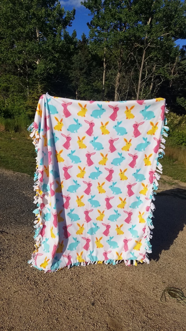 Fuzzy fleece tie blanket with colorful bunnies on it made by the Horse of Course 4-H club