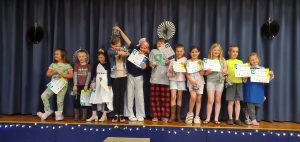 Group of Style Revue kids showing of their certificates, prizes, and sewing projects