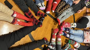 Kids showing off their holiday socks laying in a circle