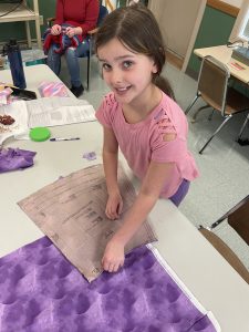 4-H youth laying a pattern piece over her fabric