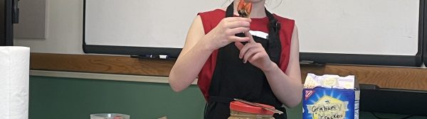 Public speaking youth holding up their finished fruit face snack