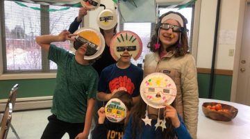 4-H youth posing with paper plate sun masks and eclipse glasses