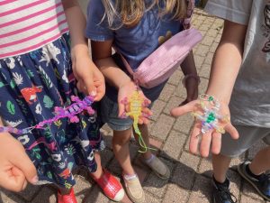 Youth holding bead lizard keychains of various colors