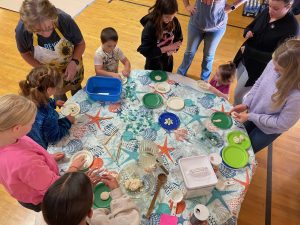 Overhead shot of several youth molding salt dough on a table