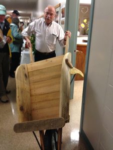 Tom donates his wooden wheelbarrow