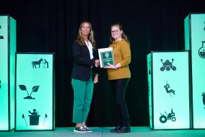 4-H staff member, Andrea, receiving a national 4-H award on stage at national convention.