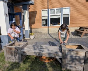 Youth repairing a bench for their school.