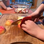 Youth learning to cut apples safely.