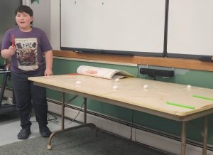 Youth sharing how to play his game.