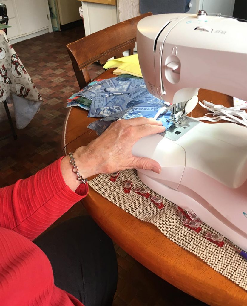 a senior woman getting ready to sew a protective mask