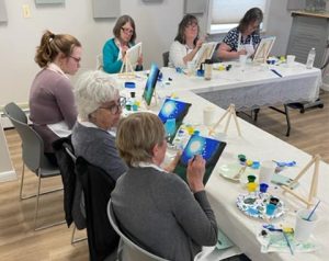 a group of women working on artistic paintings