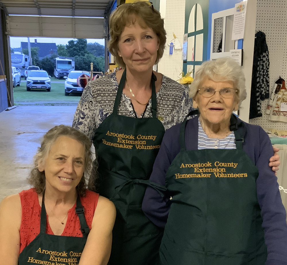 Aroostook County Extension Homemakers. L-R Marianne Thomas, Janie Schaefer and Betty Ryder, Spragueville, new aprons at the fair.