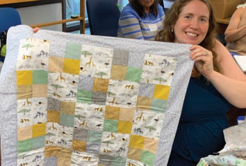 Emily Bofia holding up a quilt made by Lauree Swift, Somerset County