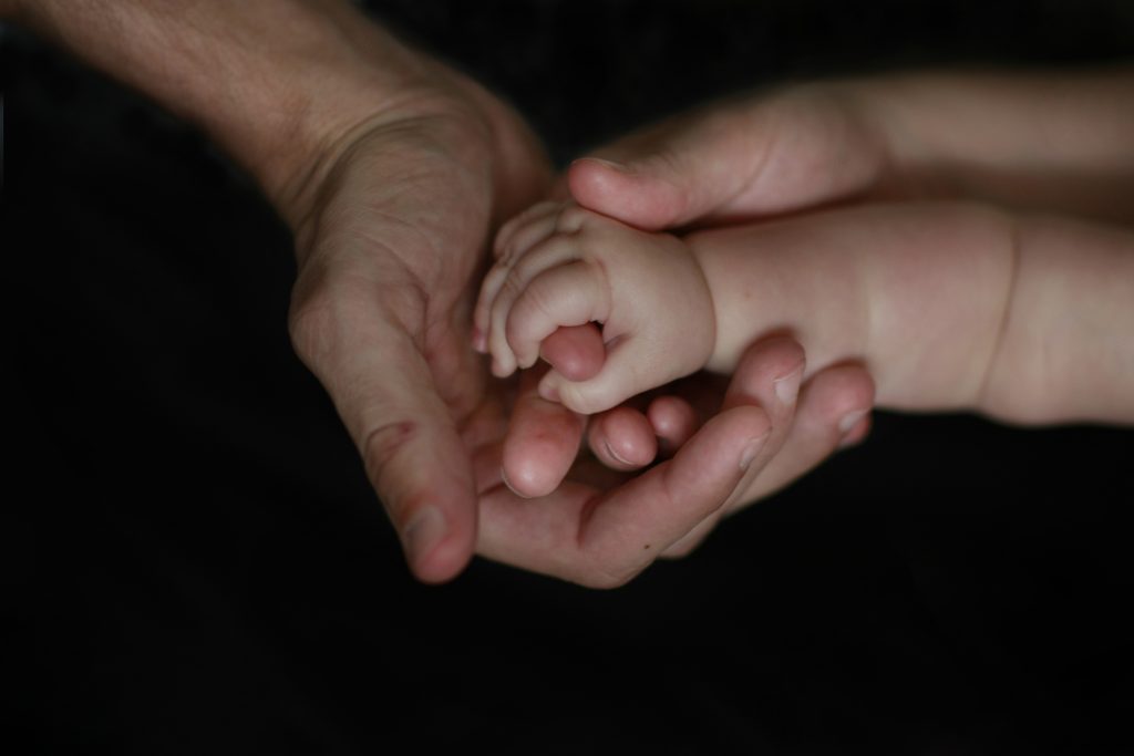 Photo of baby and adult hands