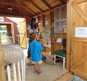 4-H member assisting child at 4-H Farm-to-Fair exhibit