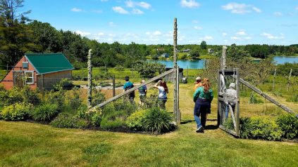 people entering a garden gate with harbor in the background