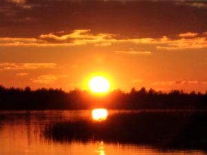 Orange sun setting over a lake