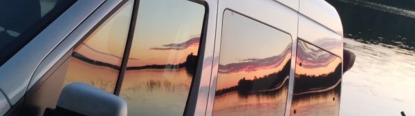 white van at boat launch with sunset reflected in windows