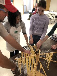 youth learning to roll pasta