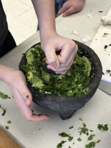 guacamole being made in a molcajete