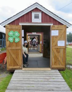small barn with 4-H clover and people inside