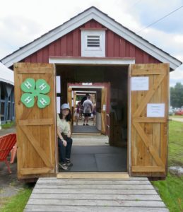 small barn with 4-H clover and people inside