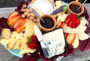 platter of various cheeses, fruits, and spreads