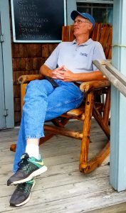 Man sitting in rocking chair on front porch