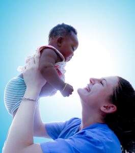 Young woman holding a toddler in the air