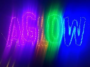 blurred image of letters spelling AGLOW traced in multi-colored lights