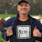 Dairy farmer shows off T-shirt, which says, "Proud to be a farmer"