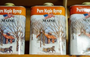 cans of maple syrup on a shelf