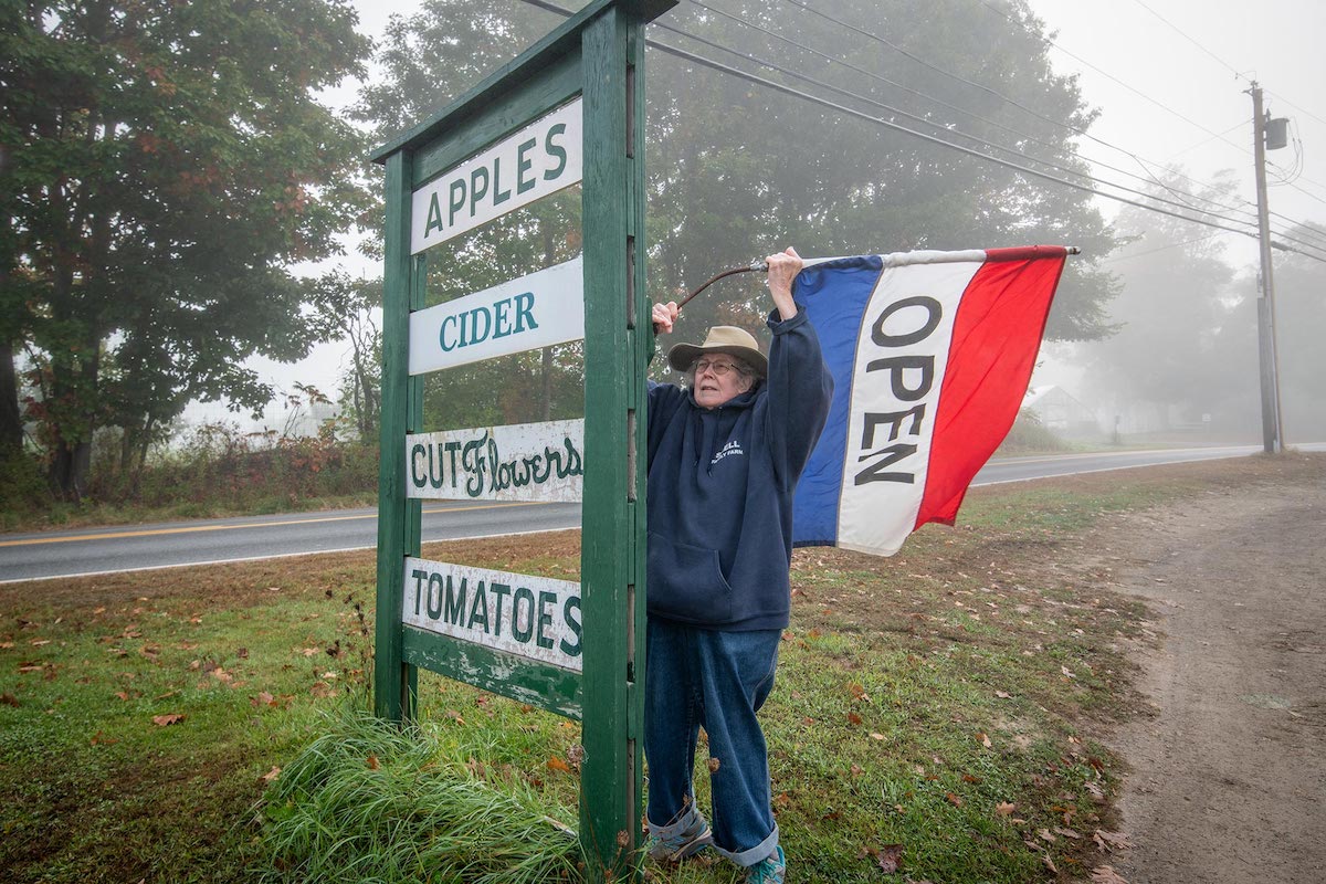 person setting an open flag at Snell Family Farm