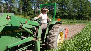 woman farmer on tractor plowing field
