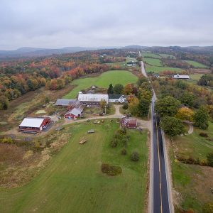 aerial view of a farm with gardens and a barn