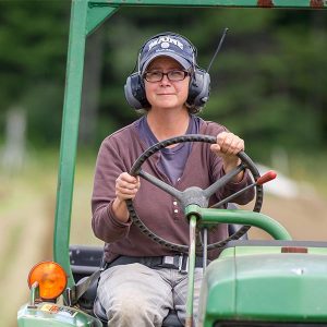 person riding a tractor wearing proper ear protection