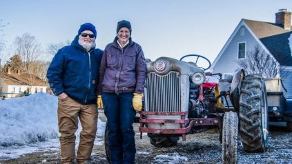 Don and Marcia Lyons standing in front of tractor on their farm