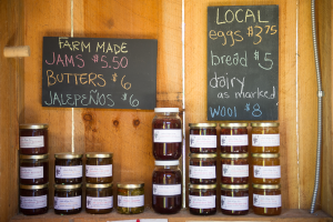 jars of farm products, jams, in a wooden shed farm stand