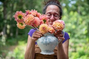 Woman holds vase of cut flowers