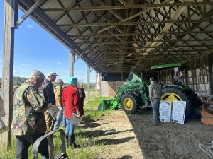 Group of people in a barn learning about tractor safety