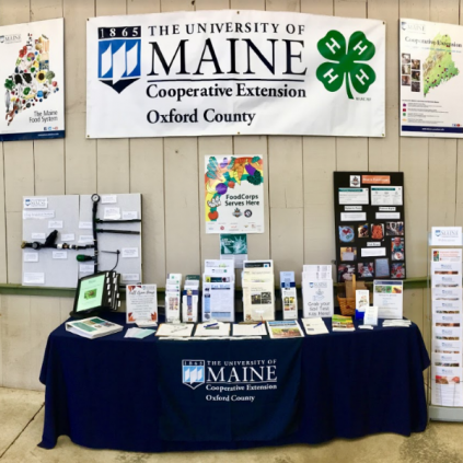 Oxford County Cooperative Extension booth at Fryeburg fair with banner and flyers